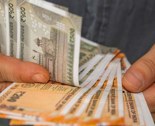 India money, Man counts Indian rupees, Close-up of hands with banknotes. Cash in denominations of 200 and 500